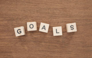 top view of 'goals' word made of wooden blocks on wooden tabletop, goal setting concept