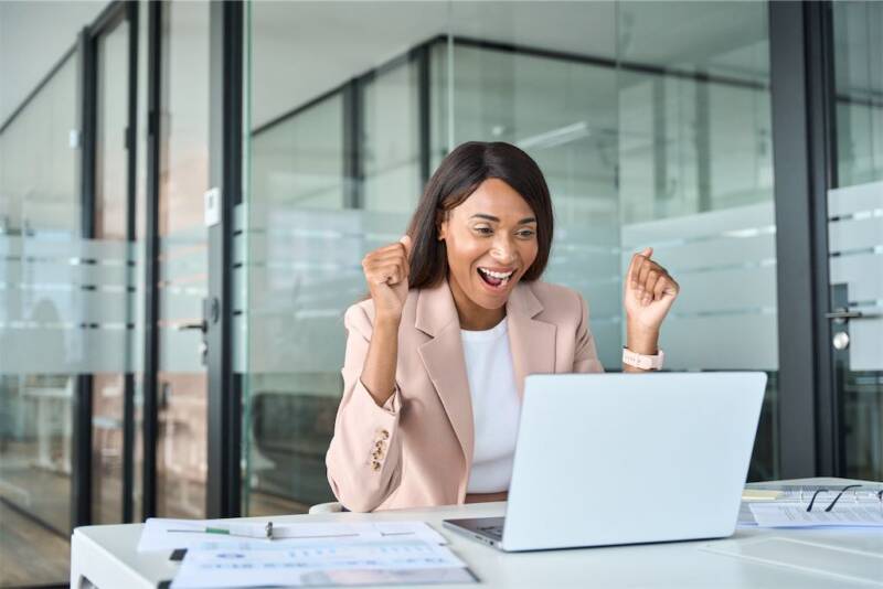 excited young business woman looking at laptop