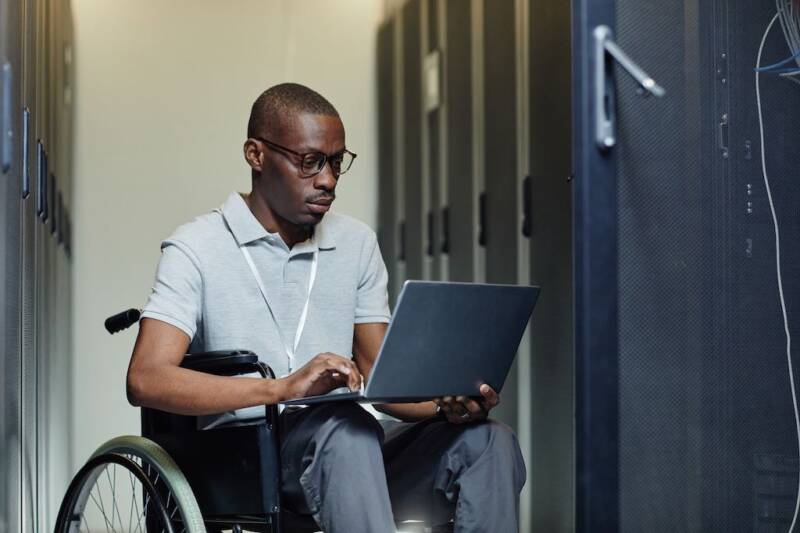man in wheelchair with laptop working